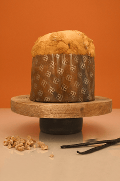 Panettone Le Bec Sucré à l'érable entier sur un présentoir avec noix et vanille