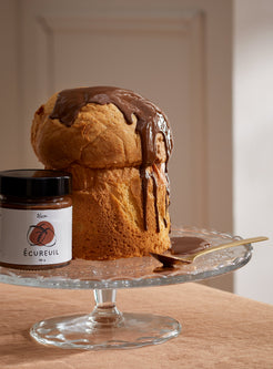 L'Écureuil noisette : panettone nappé de tartinade aux noisettes et son pot sur un présentoir en verre