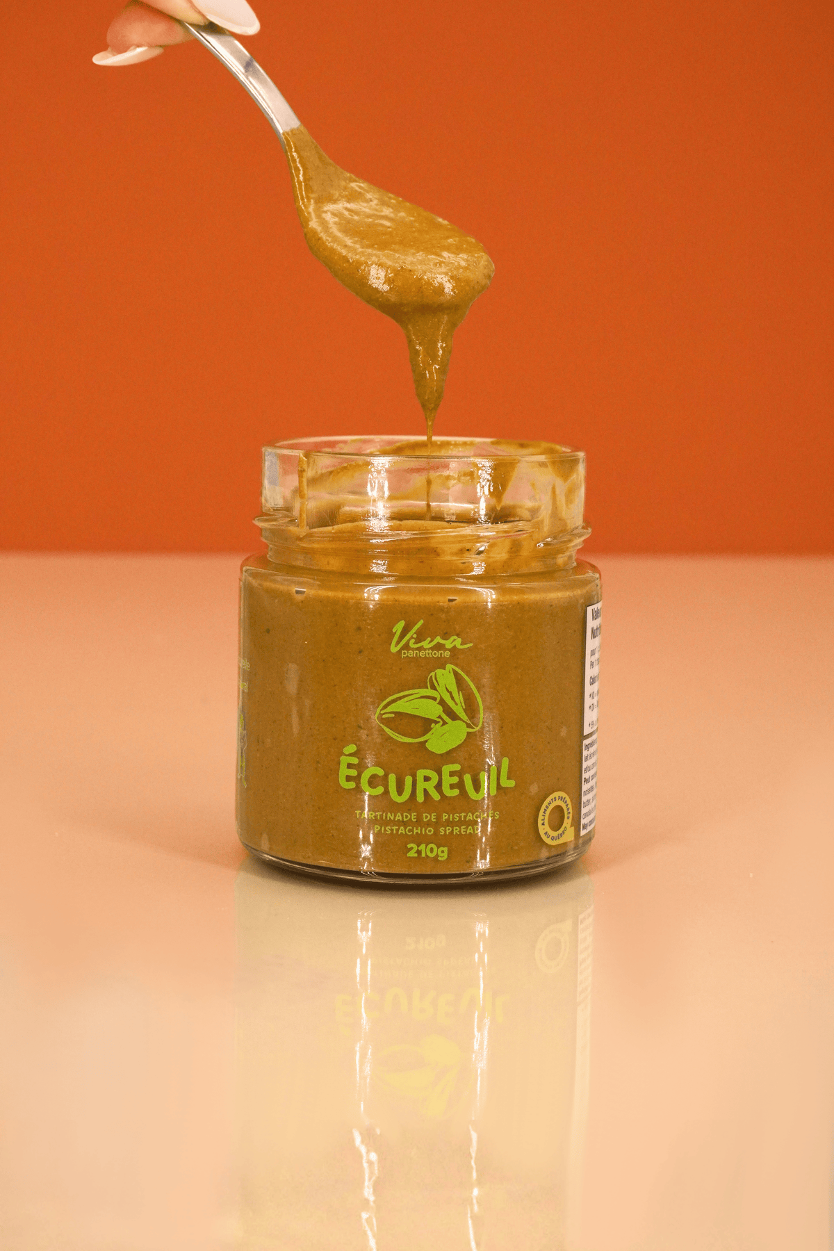 Cuillère de tartinade L'Écureuil pistache au-dessus du pot