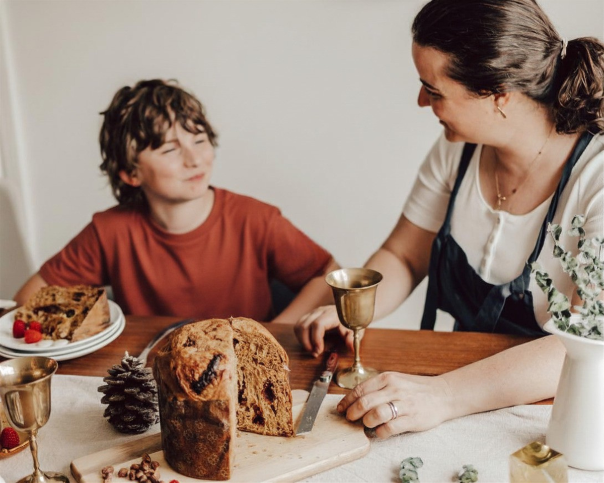 Mère et fils rient en partageant un panettone